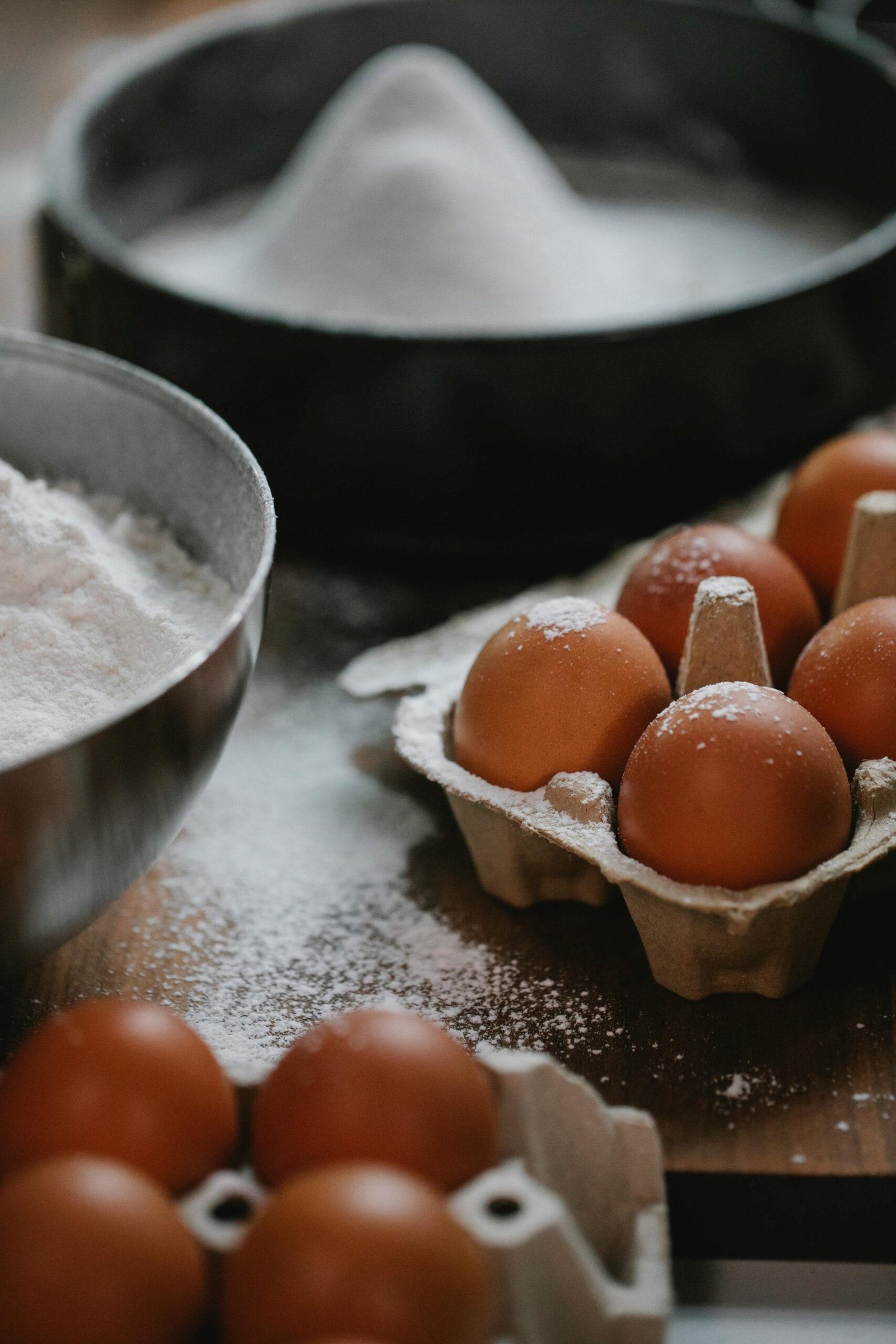 Close-up of eggs in a tray with flour in a bowl, perfect for baking themes.